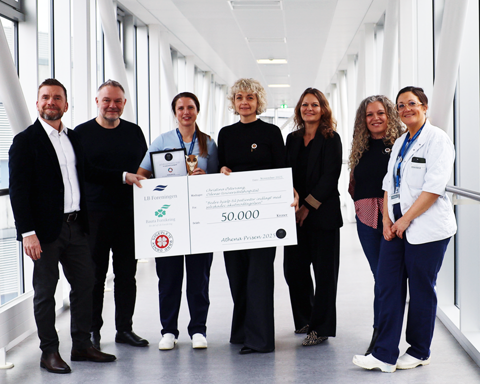 7 mennesker på glasgang med stor check