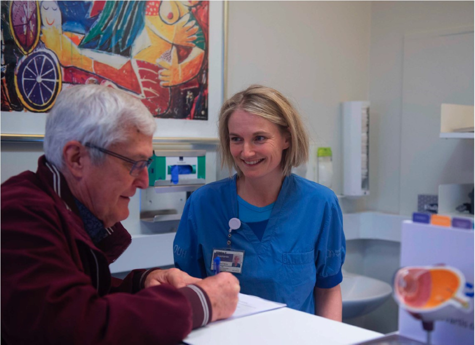 Sygeplejerske har en samtale med patient til en ambulant undersøgelse..